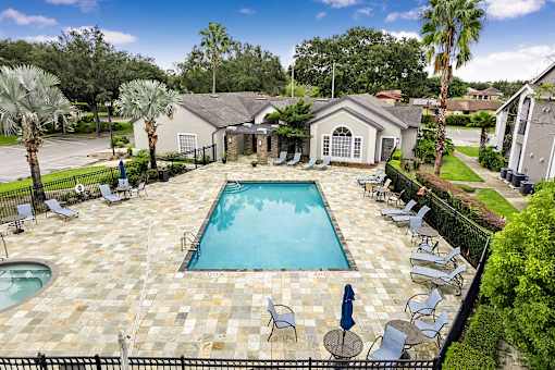 A pool surrounded by chairs and umbrellas.