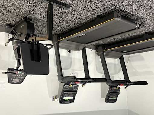 A row of three black bicycle computers are attached to the handlebars of a bike.