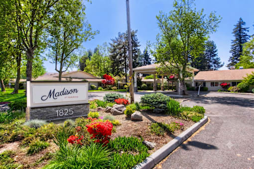A sign that says "Madison" is in front of a building.
