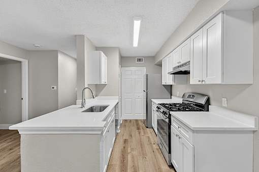 A kitchen with white cabinets and appliances.