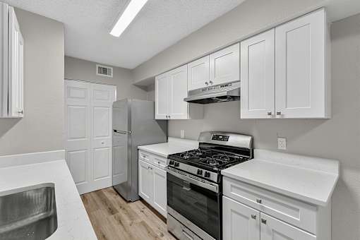 A kitchen with white cabinets and stainless steel appliances.