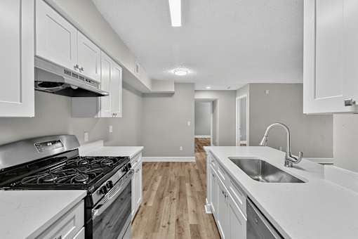 A kitchen with a stove top oven and a sink.