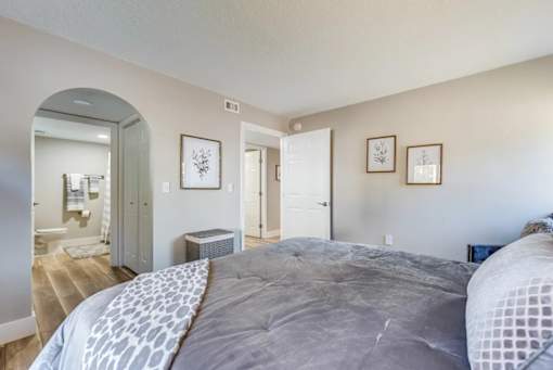 A bedroom with a large bed and a mirror on the wall.