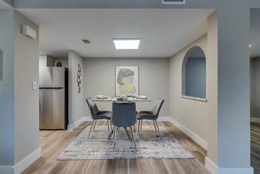 A modern dining room with a table set for four.