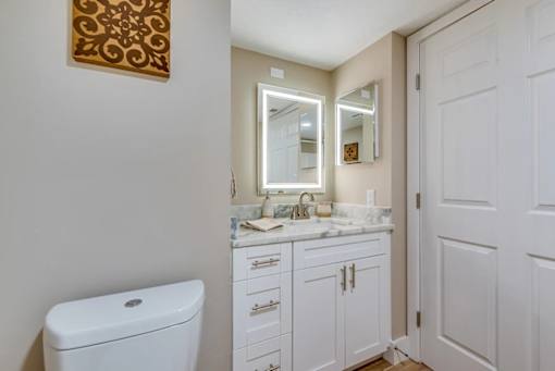A white toilet sits next to a sink in a small bathroom.