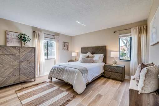 A bedroom with a large bed and a wooden chest of drawers.