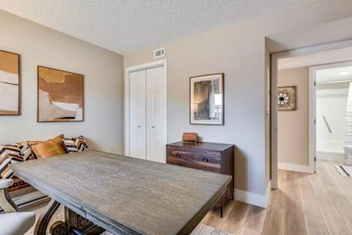 A dining room with a wooden table and chairs.