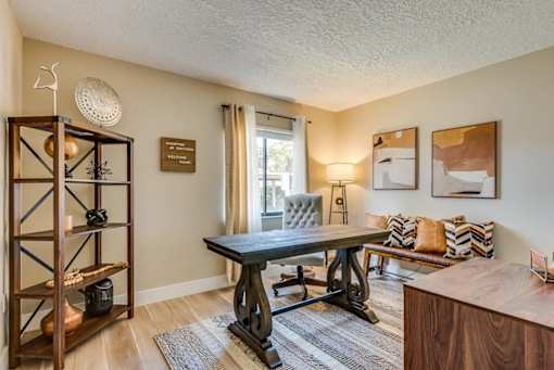 A room with a wooden table and a grey chair.