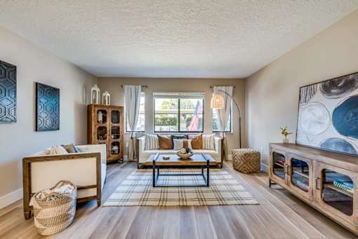 A living room with a couch, a coffee table, and a large painting on the wall.