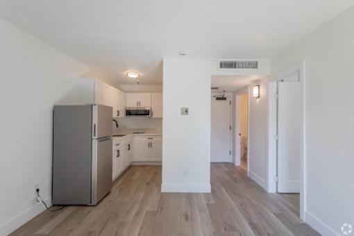 A kitchen with a refrigerator, microwave, and oven.
