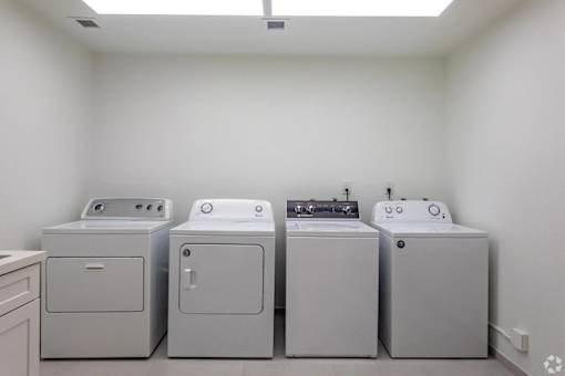 A row of washing machines in a laundry room.