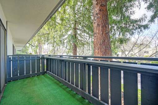 A balcony with a green carpet and a railing.