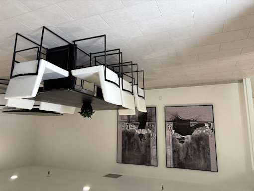 A white ceiling with a black and white photo hanging on the wall.