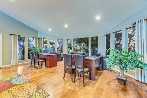 a dining room with a table and chairs and a living room with windows