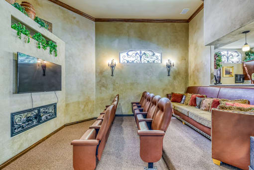 a theater room with leather chairs and a couch