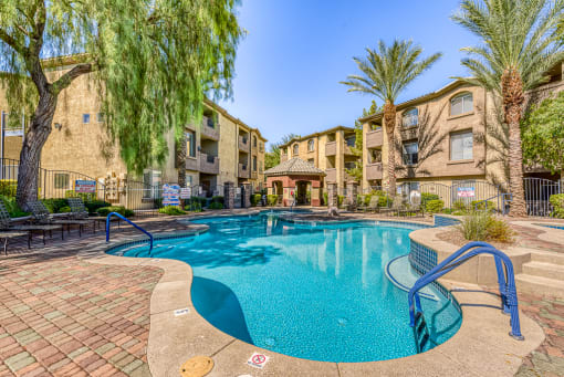 a swimming pool with an apartment building in the background