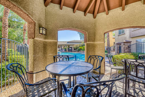 a patio with a table and chairs and a swimming pool
