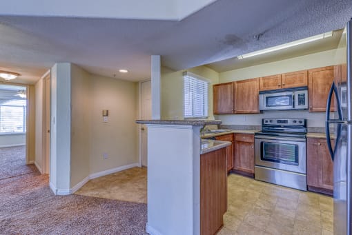 a kitchen with wooden cabinets and stainless steel appliances