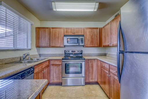a kitchen with wooden cabinets and stainless steel appliances