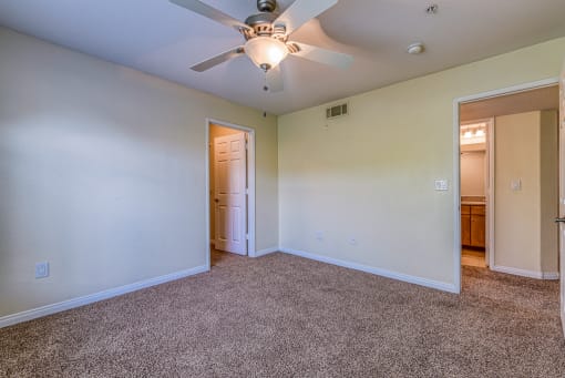 the living room of an empty house with a ceiling fan
