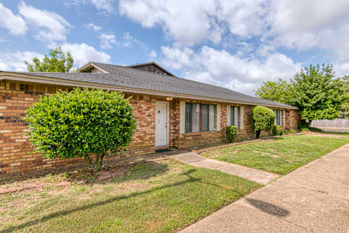 A brick house with a white door and windows.