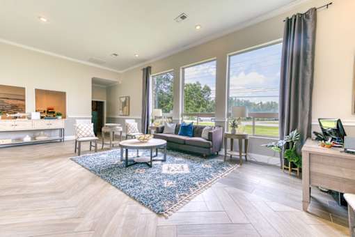 A spacious living room with a large window overlooking a green landscape.