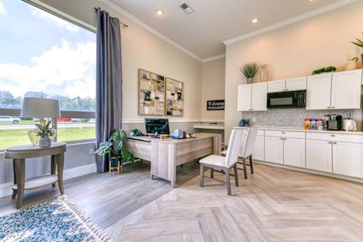 A modern kitchen with a desk and chair in the middle of the room.