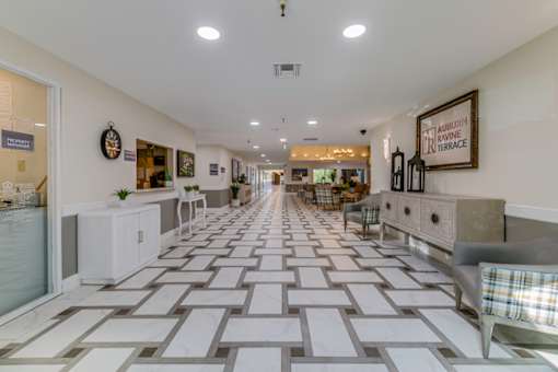 A long hallway with a checkered floor and a sign that says "Hamptons".