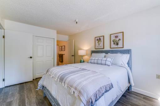 A bedroom with a large bed and a white door.