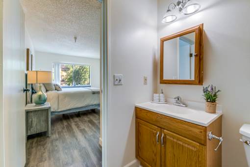 A bathroom with a wooden vanity and a mirror above it.