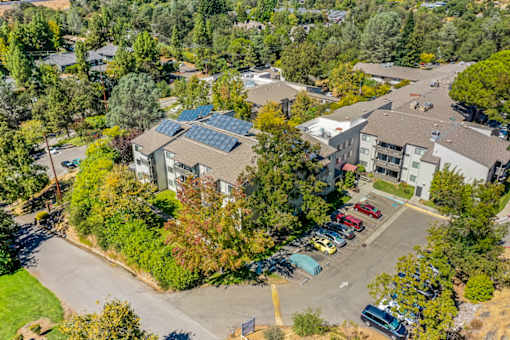 A parking lot with cars and a building with solar panels.