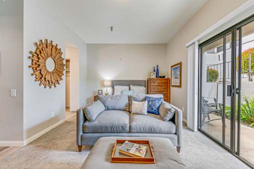 A living room with a grey couch and a wooden tray on the coffee table.