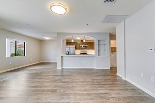 A spacious kitchen with a refrigerator, microwave, and oven, with a bar area in the middle.