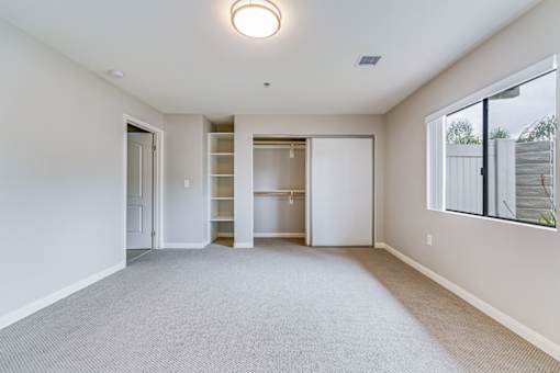 A spacious room with a carpeted floor and a ceiling light.