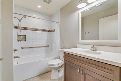 A white bathroom with a toilet, sink, and a shower with a glass door.