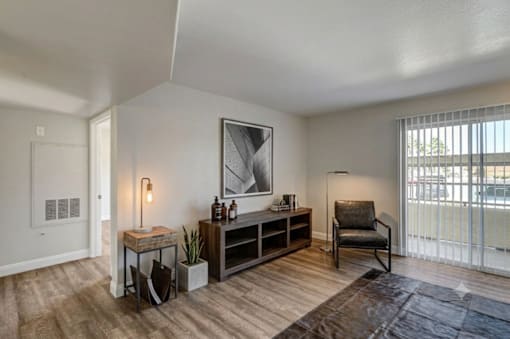 A room with a chair, a table, and a painting on the wall.