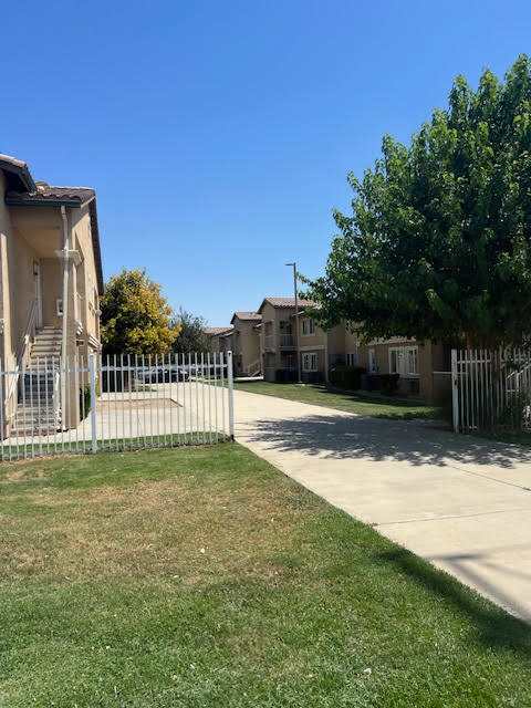 A row of houses with a fence in front.
