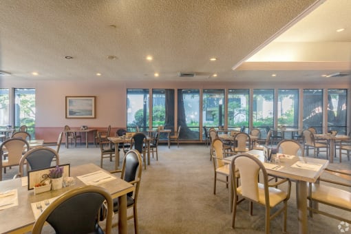 a dining room with tables and chairs and windows in a restaurant
