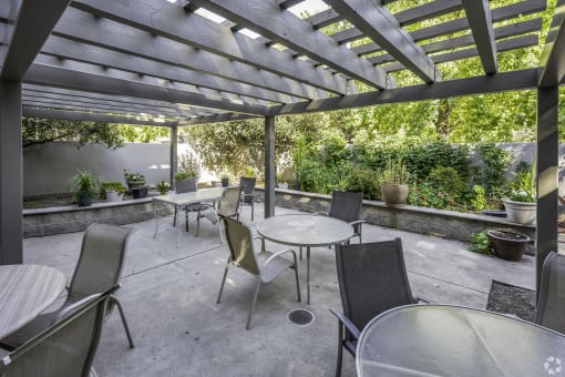 a patio with tables and chairs and a pergola