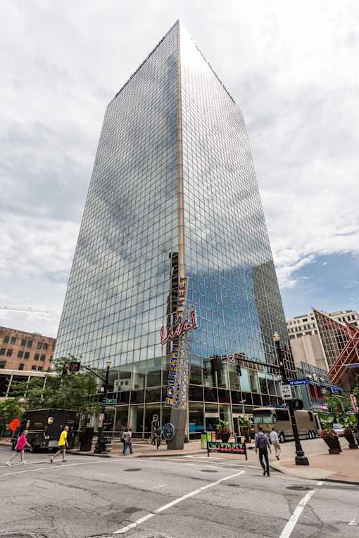 a tall building with a reflection of the sky in it