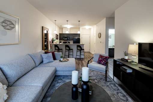 a living room and kitchen with a couch and a table