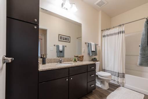 an open bathroom with a large mirror and a toilet and sink