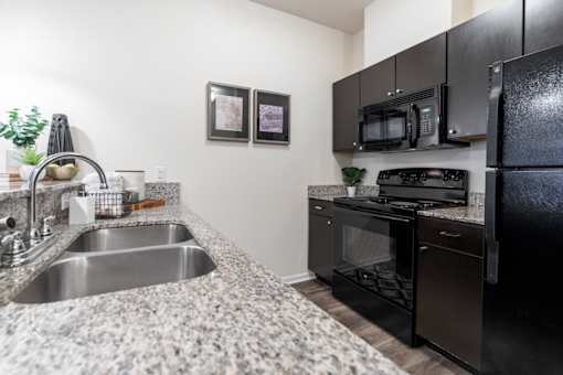 a kitchen with granite counter tops and black appliances