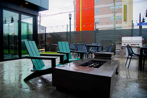a patio with chairs and a fire pit