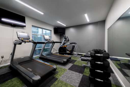 a gym with treadmills and other exercise equipment in a building