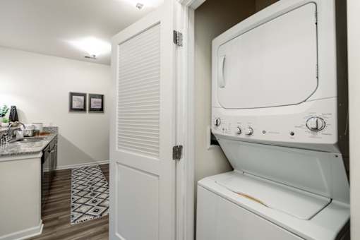 a washer and dryer in a laundry room with a sink and a door
