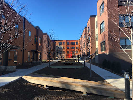A courtyard surrounded by buildings with a playground in the middle.