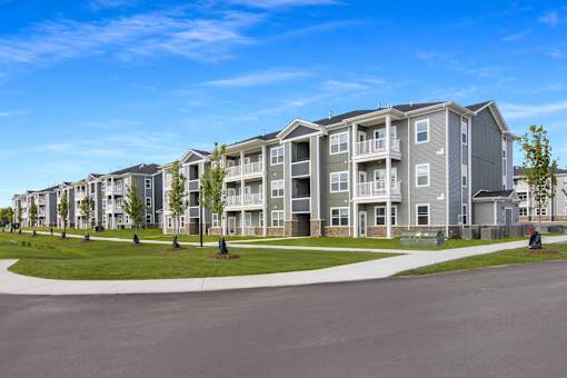 A row of modern apartment buildings with green lawns in front.