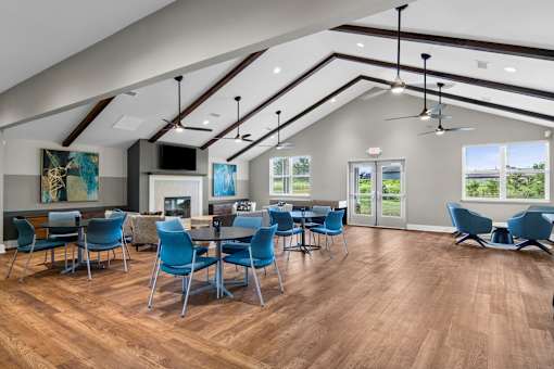 A modern dining room with blue chairs and a wooden floor.