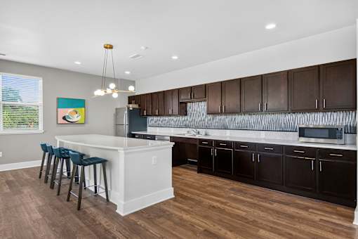 A kitchen with a white island and dark brown cabinets.